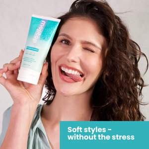 A woman holding a Curly Hair Cream bottle playfully