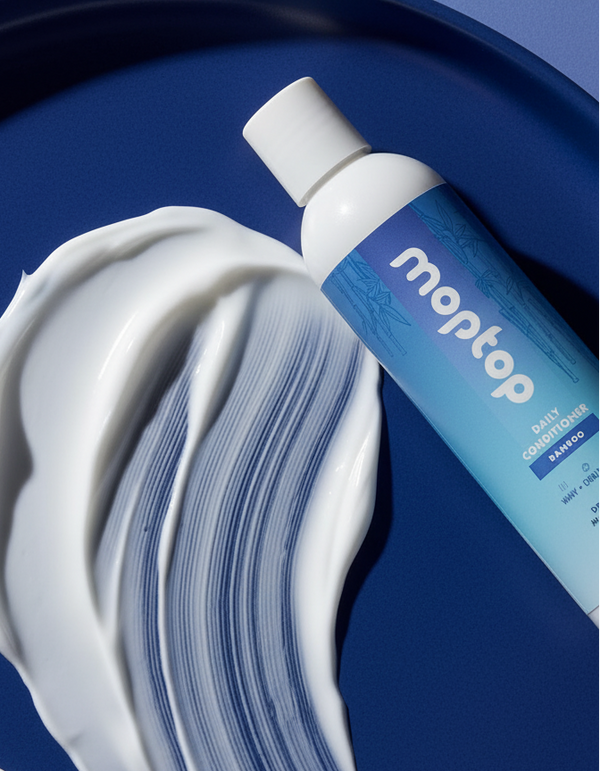 A Daily Conditioner Bottle next to a smear of its conditioner