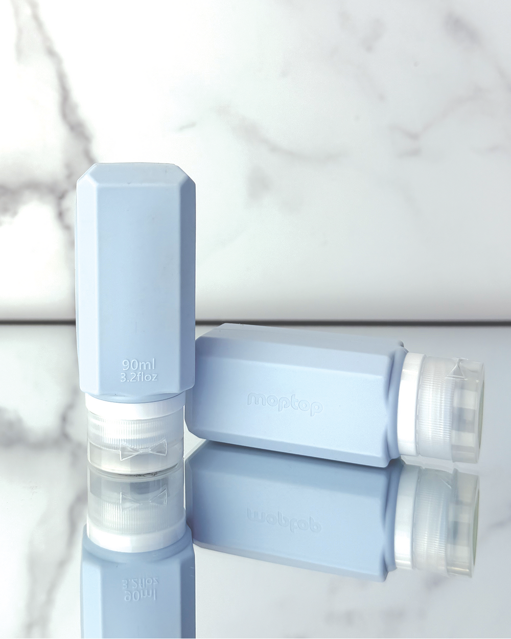 Light blue silicone bottles on a mirror