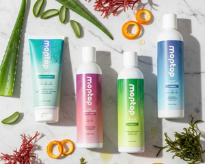 The wavy hair bundle surrounded by aloe, citrus rind, and seaweed