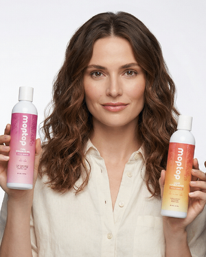 A woman holding bottles of Leave In Conditioner and Light Conditioner